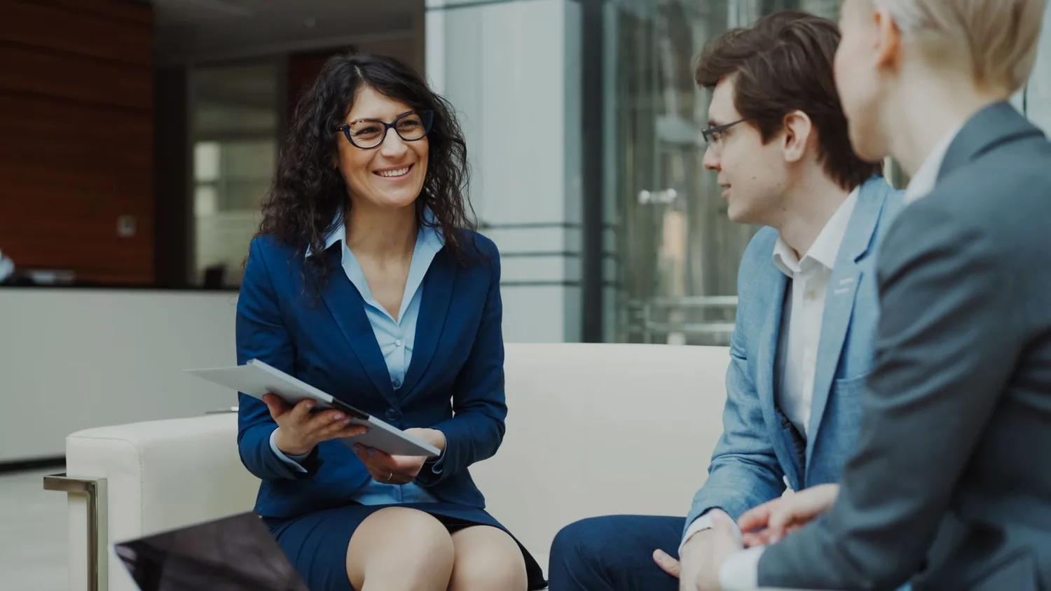 A small group of business leaders in conversation in a contemporary meeting space