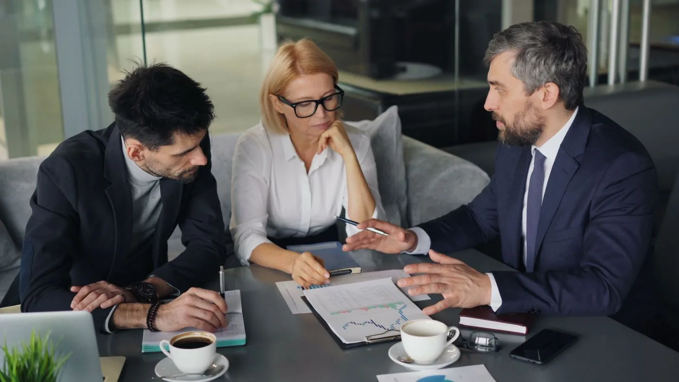 Business leaders listening and discussing around a meeting table