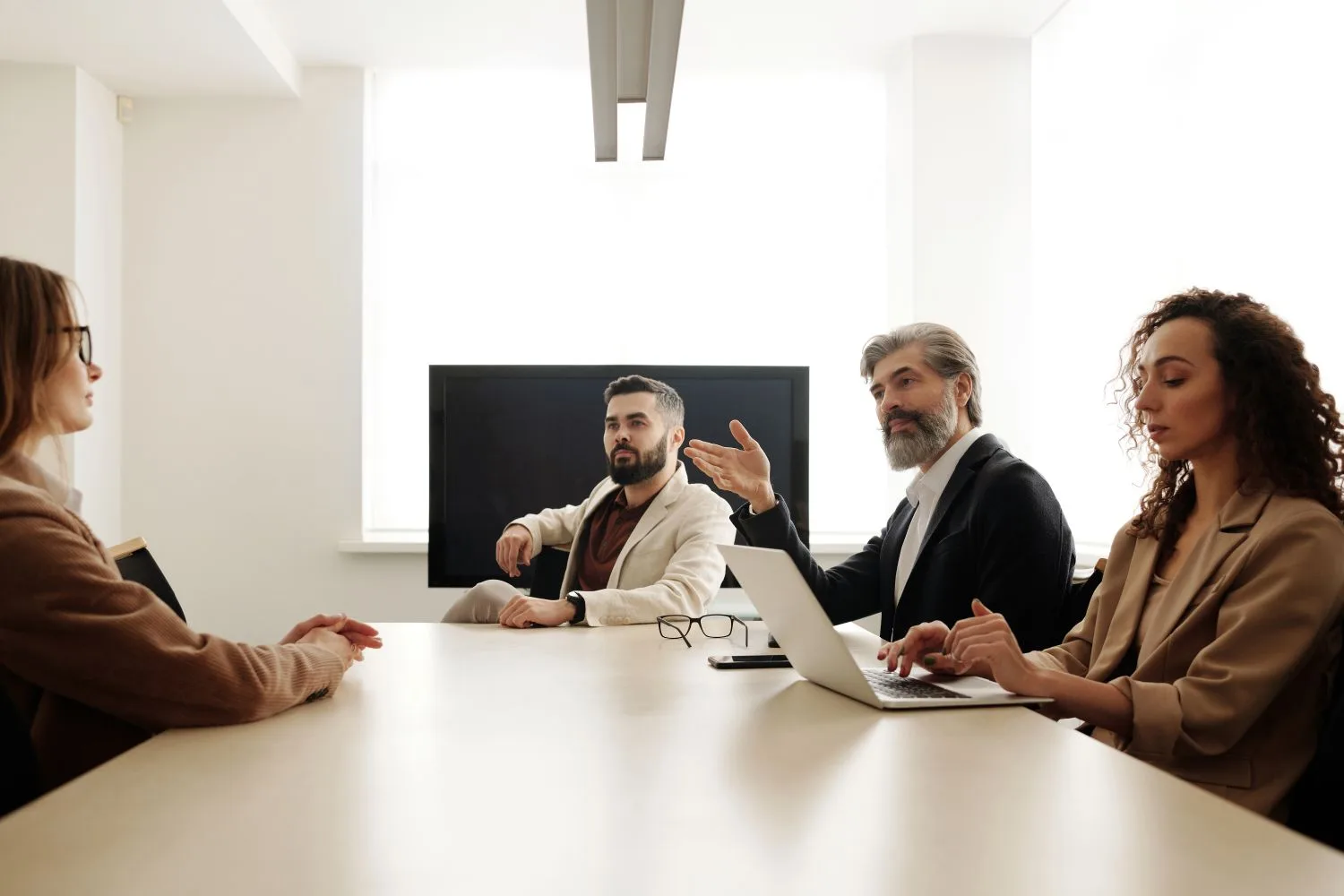 Leadership team sharing perspectives around a boardroom table